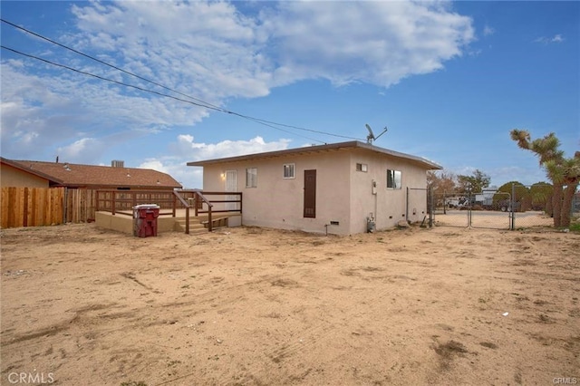 6454 Goleta Ave, Yucca Valley, CA 92284 - back of property featuring stucco siding, a gate, and a deck
