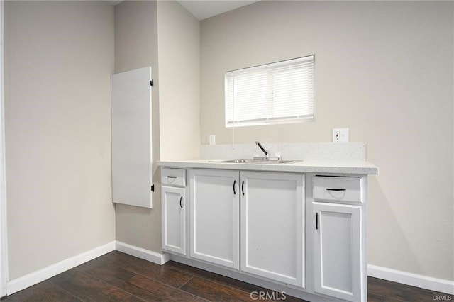 kitchen with white cabinetry, dark wood-type flooring, and sink