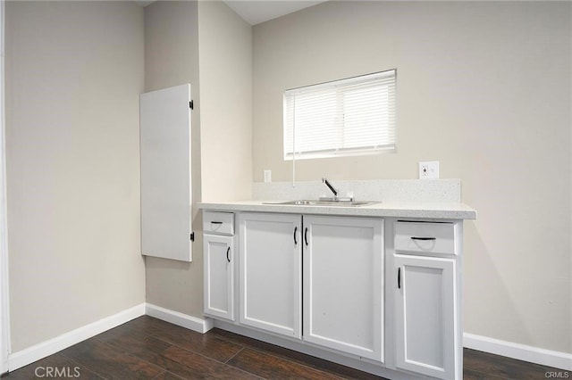 6454 Goleta Ave, Yucca Valley, CA 92284 - kitchen featuring a sink, baseboards, dark wood-style flooring, light countertops, and white cabinets