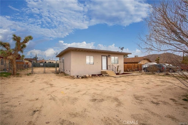 6454 Goleta Ave, Yucca Valley, CA 92284 - rear view of house featuring stucco siding and a gate