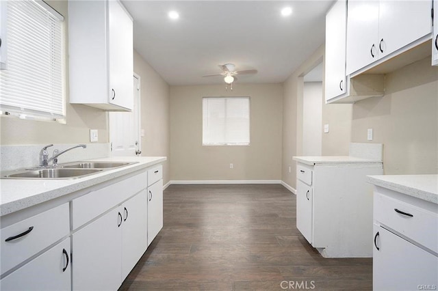 kitchen featuring white cabinets, ceiling fan, dark wood-type flooring, and sink