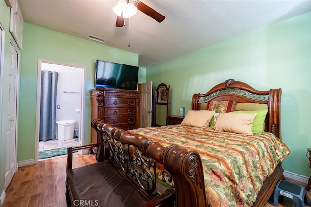 bedroom with connected bathroom, ceiling fan, and hardwood / wood-style flooring