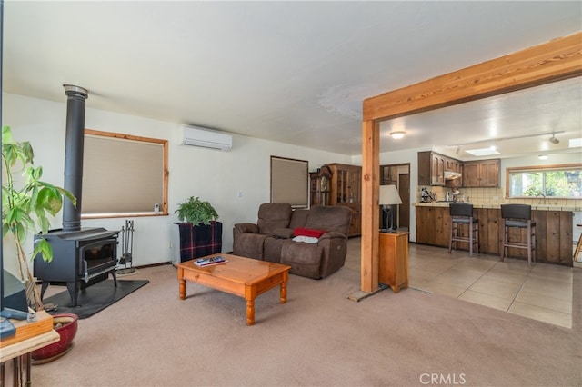 carpeted living room with a wall mounted air conditioner, sink, and a wood stove