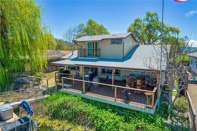 back of house featuring a deck and a balcony