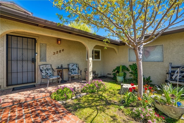 doorway to property with a patio and a lawn