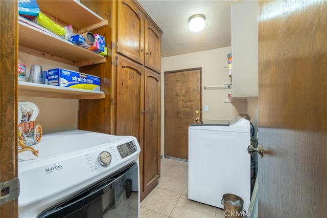 laundry area featuring cabinets, washing machine and dryer, and light tile patterned floors