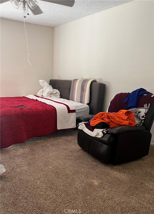 carpeted bedroom featuring ceiling fan and a textured ceiling