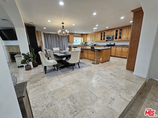 dining space featuring a notable chandelier and a fireplace