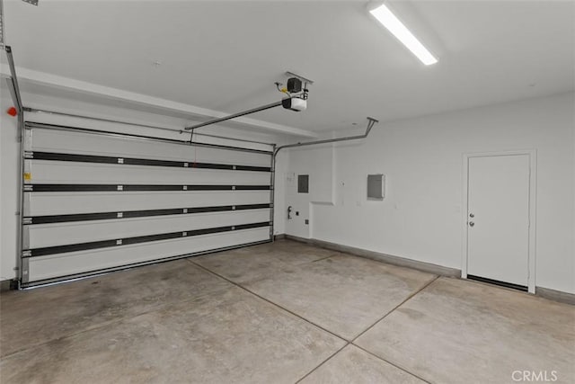 garage with baseboards, a garage door opener, and electric panel