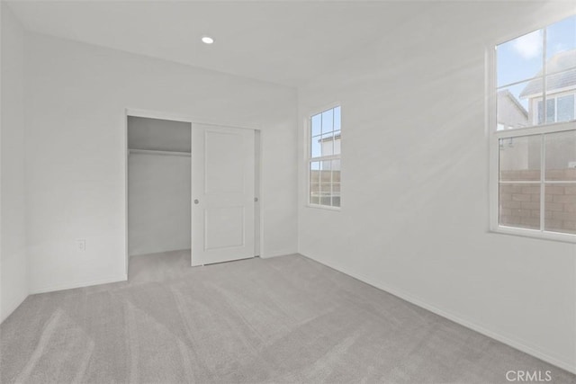unfurnished bedroom featuring a closet, carpet, and recessed lighting
