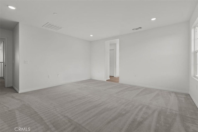 empty room with visible vents, carpet, and recessed lighting