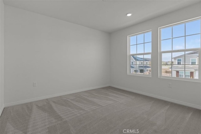 spare room featuring recessed lighting, baseboards, and carpet floors