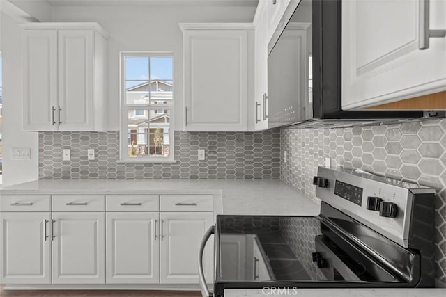 kitchen with white cabinetry, tasteful backsplash, and stainless steel electric stove