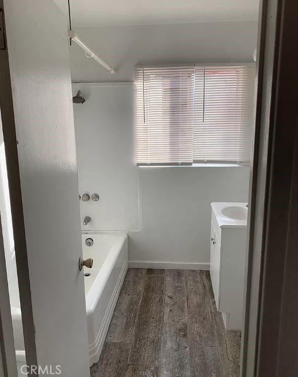 bathroom featuring vanity, wood-type flooring, and bathtub / shower combination