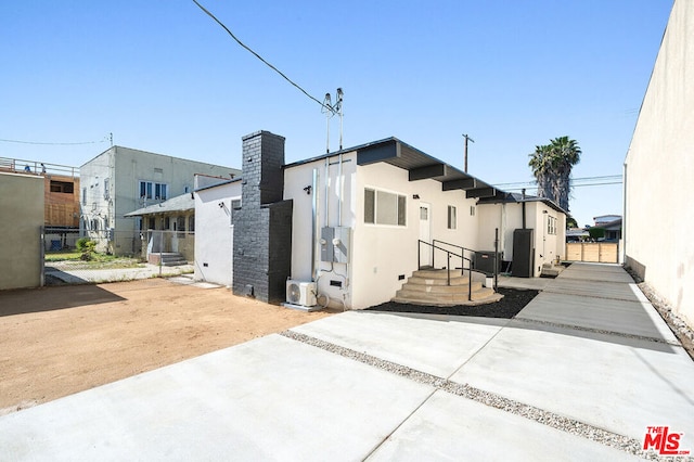 rear view of house featuring a patio area and central AC