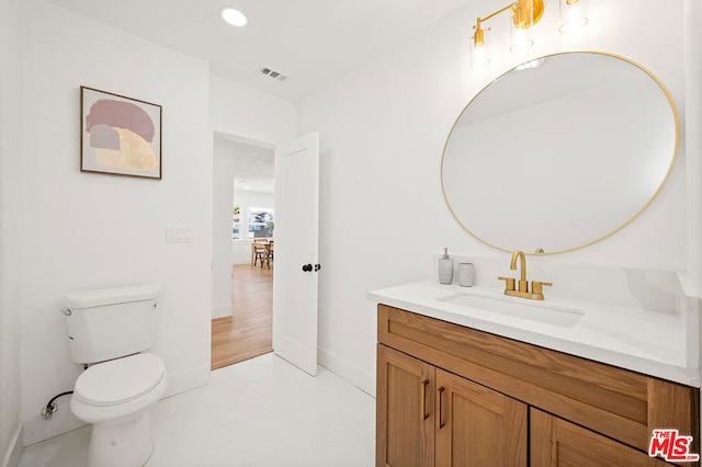 bathroom featuring toilet, tile flooring, and vanity