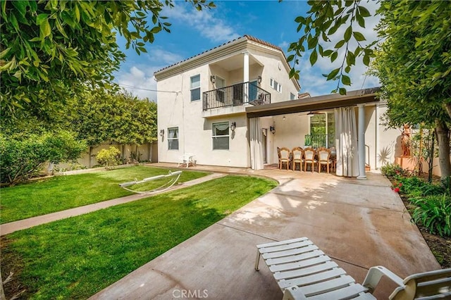 back of house featuring a balcony, a yard, and a patio