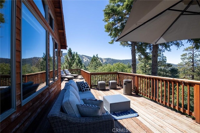 deck with outdoor lounge area and a mountain view