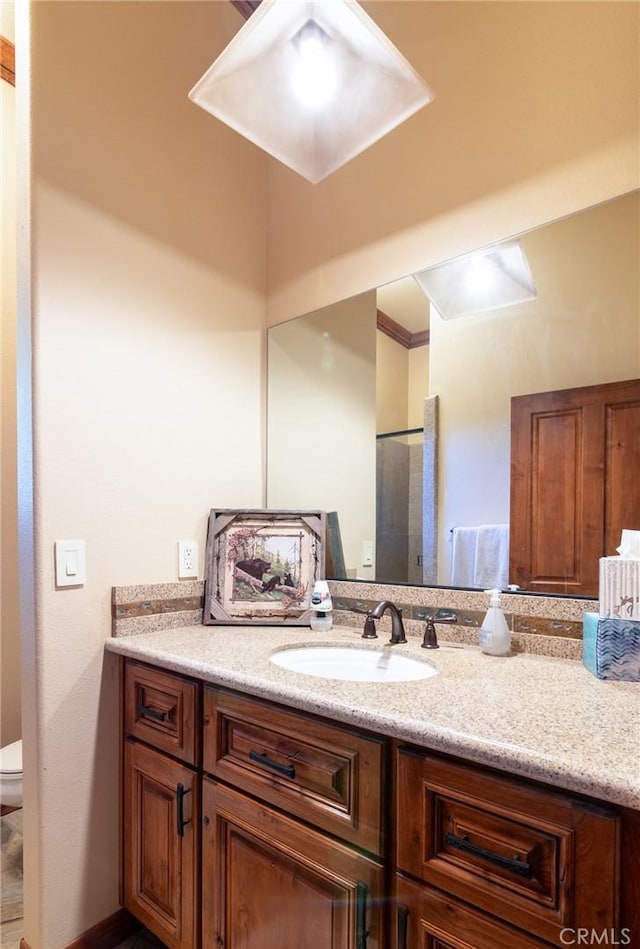 bathroom featuring vanity, toilet, and ornamental molding