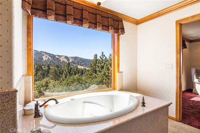 bathroom featuring a bathing tub, a mountain view, crown molding, and tile patterned floors