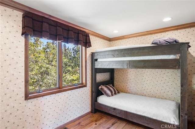 bedroom with hardwood / wood-style floors and ornamental molding