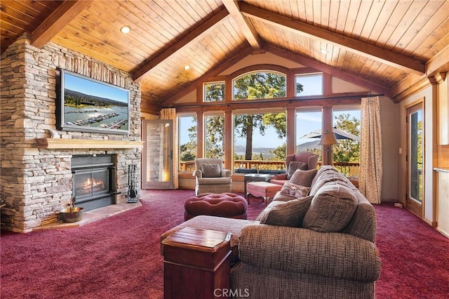 living room with beam ceiling, a stone fireplace, carpet floors, and wood ceiling