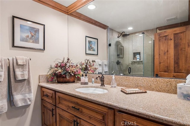 bathroom with vanity and a shower with door