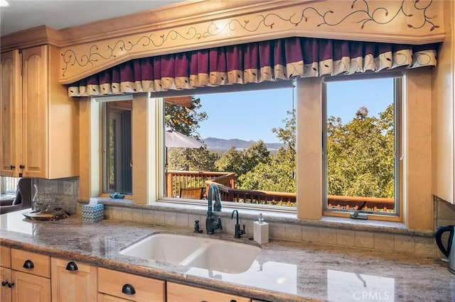 kitchen with decorative backsplash, a wealth of natural light, sink, and a mountain view