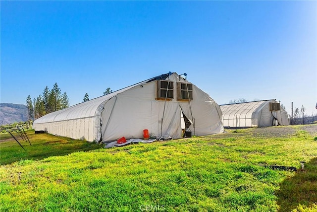 exterior space with an outdoor structure and a lawn