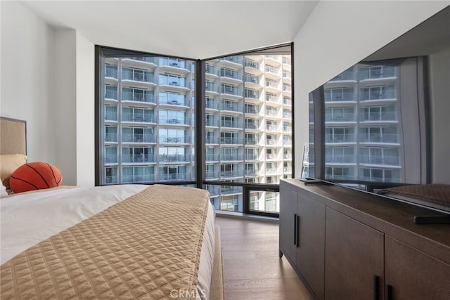 unfurnished bedroom featuring wood-type flooring and expansive windows