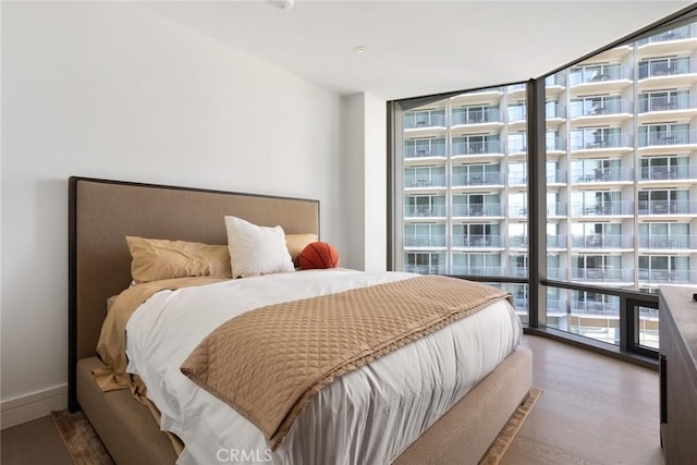 bedroom with floor to ceiling windows and dark wood-type flooring