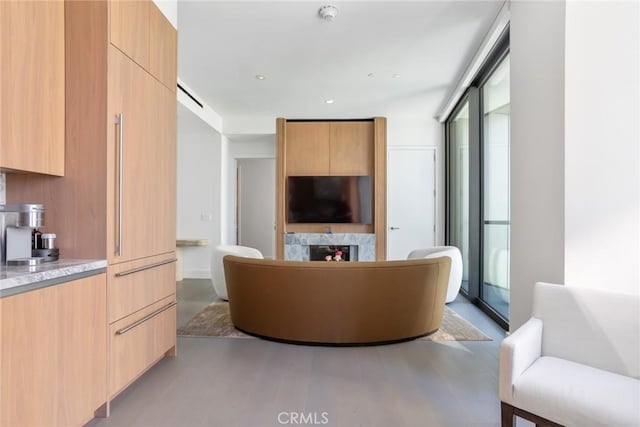 living room featuring a fireplace, expansive windows, a healthy amount of sunlight, and light wood-type flooring