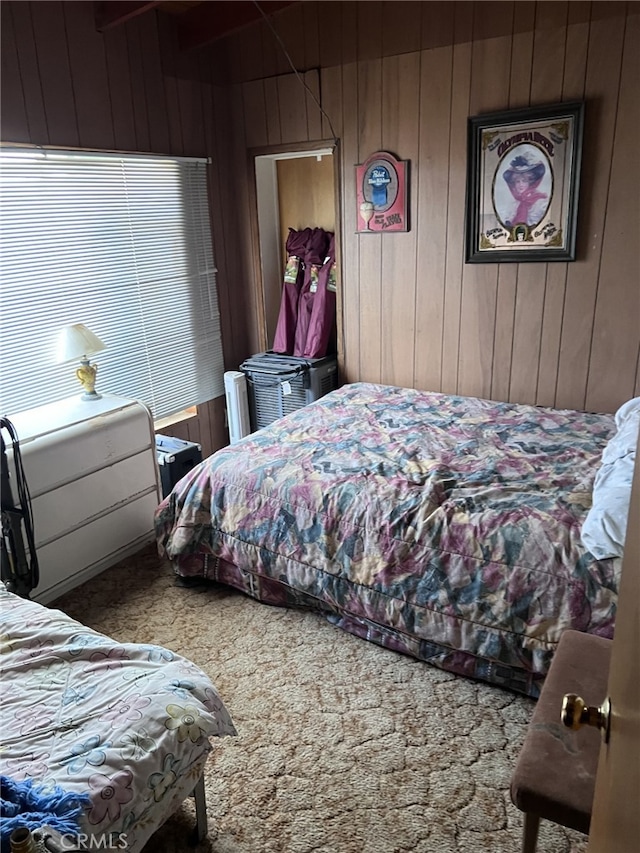 carpeted bedroom featuring wood walls