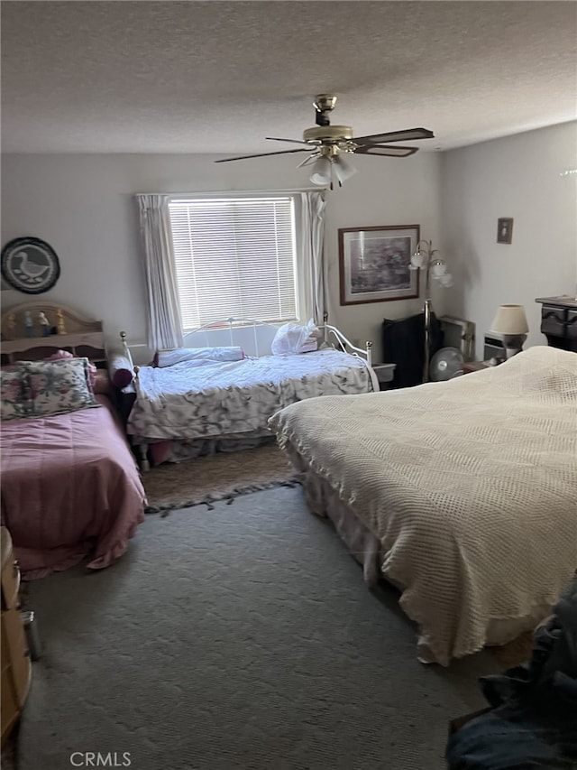 bedroom with ceiling fan, a textured ceiling, and carpet flooring