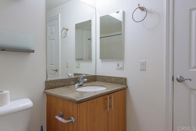 bathroom featuring vanity and toilet