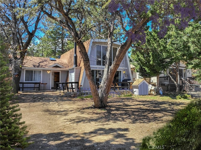 view of front of property featuring a storage shed