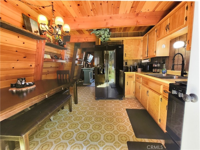 kitchen featuring black fridge, wood ceiling, sink, pendant lighting, and light tile floors