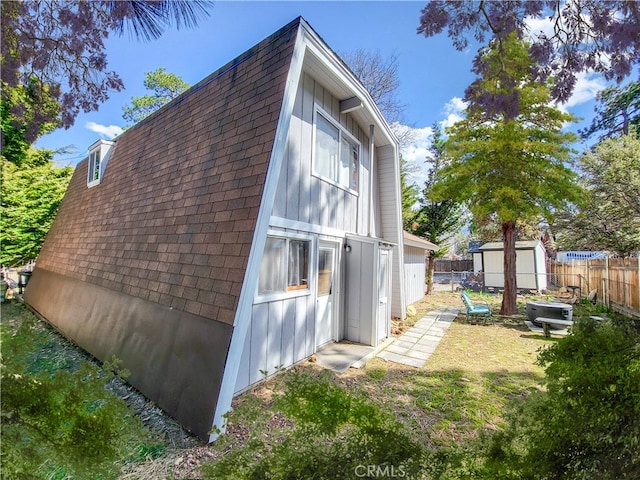 view of side of home featuring a yard and a storage shed