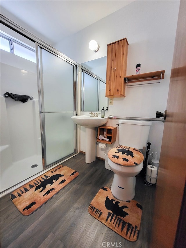 bathroom with an enclosed shower, wood-type flooring, and toilet