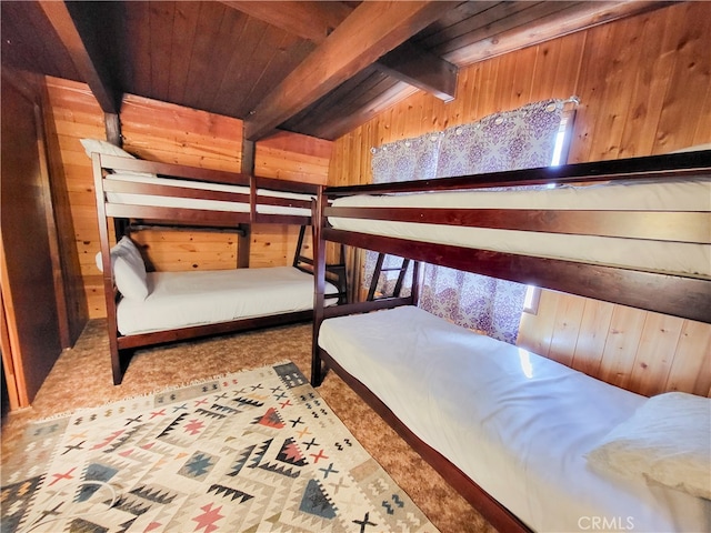 bedroom with wood walls, carpet, wooden ceiling, and vaulted ceiling with beams