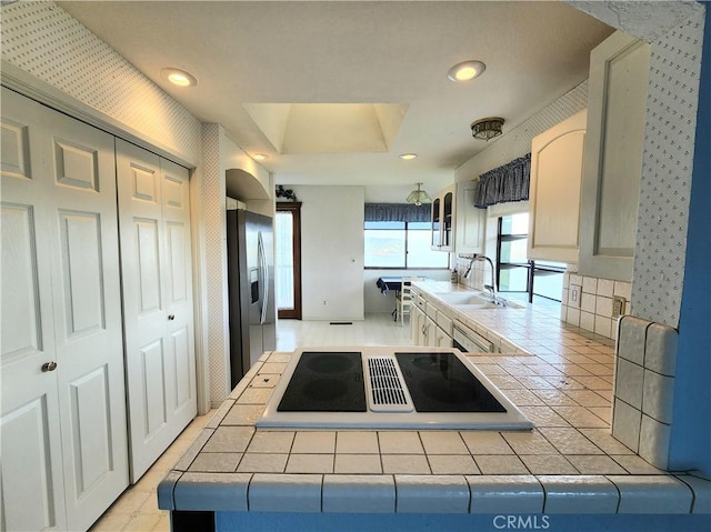 kitchen featuring tile countertops, a raised ceiling, sink, and stainless steel appliances