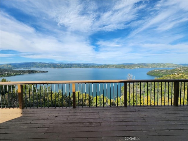 wooden deck with a water and mountain view