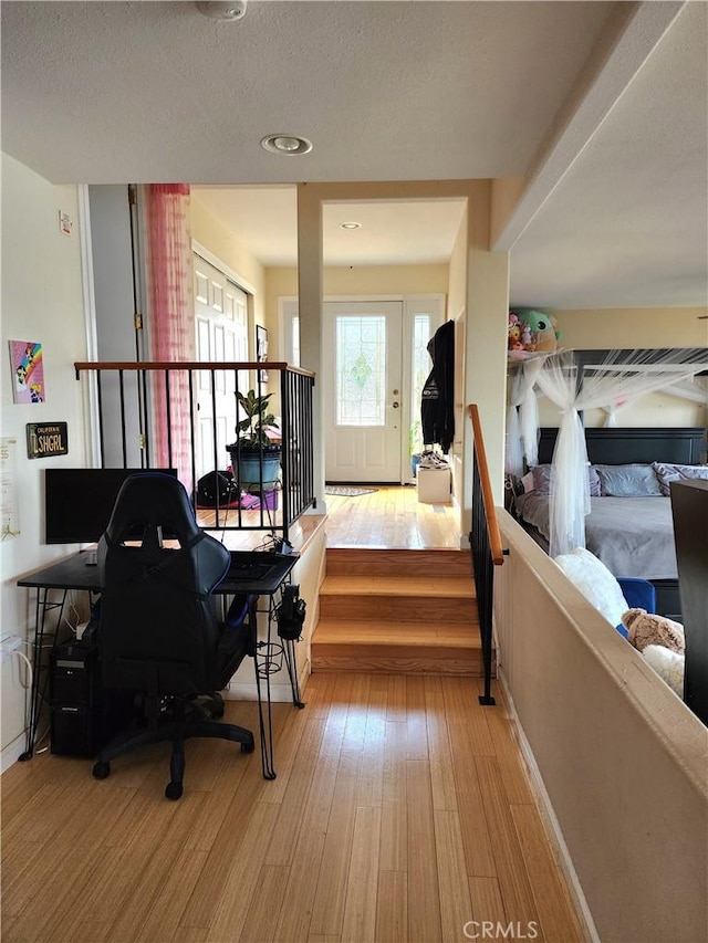 home office featuring light hardwood / wood-style floors and a textured ceiling