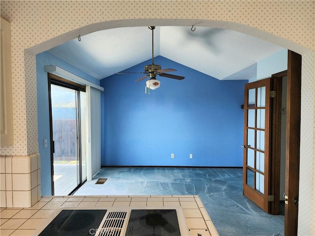 carpeted empty room featuring ceiling fan and lofted ceiling