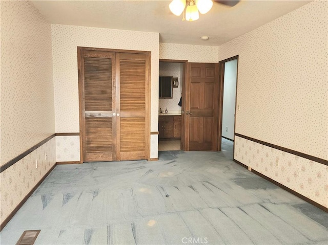 unfurnished bedroom with carpet flooring, ceiling fan, and a closet