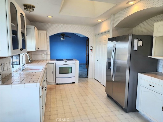 kitchen featuring white cabinetry, sink, ceiling fan, white range with electric cooktop, and stainless steel fridge