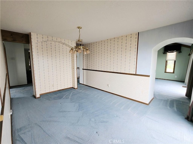 unfurnished dining area featuring carpet flooring and a notable chandelier