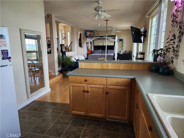 kitchen with ceiling fan, white refrigerator, kitchen peninsula, and a wealth of natural light