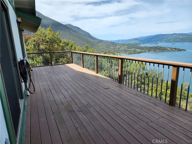 wooden deck featuring a water and mountain view