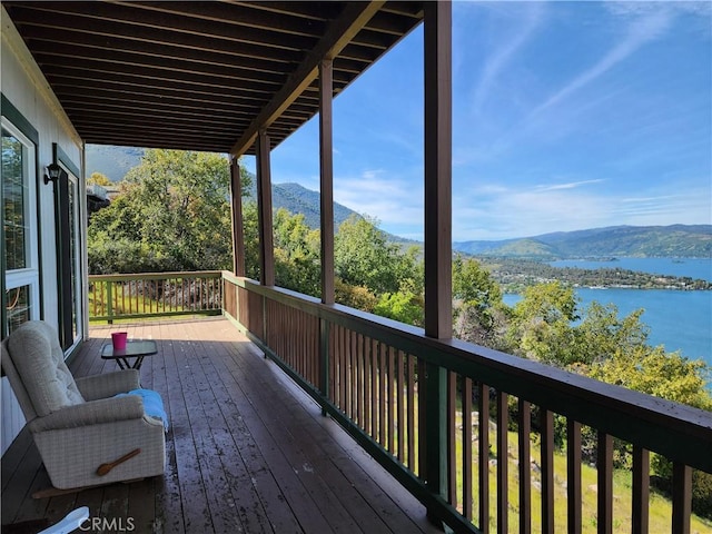 wooden terrace featuring a water and mountain view